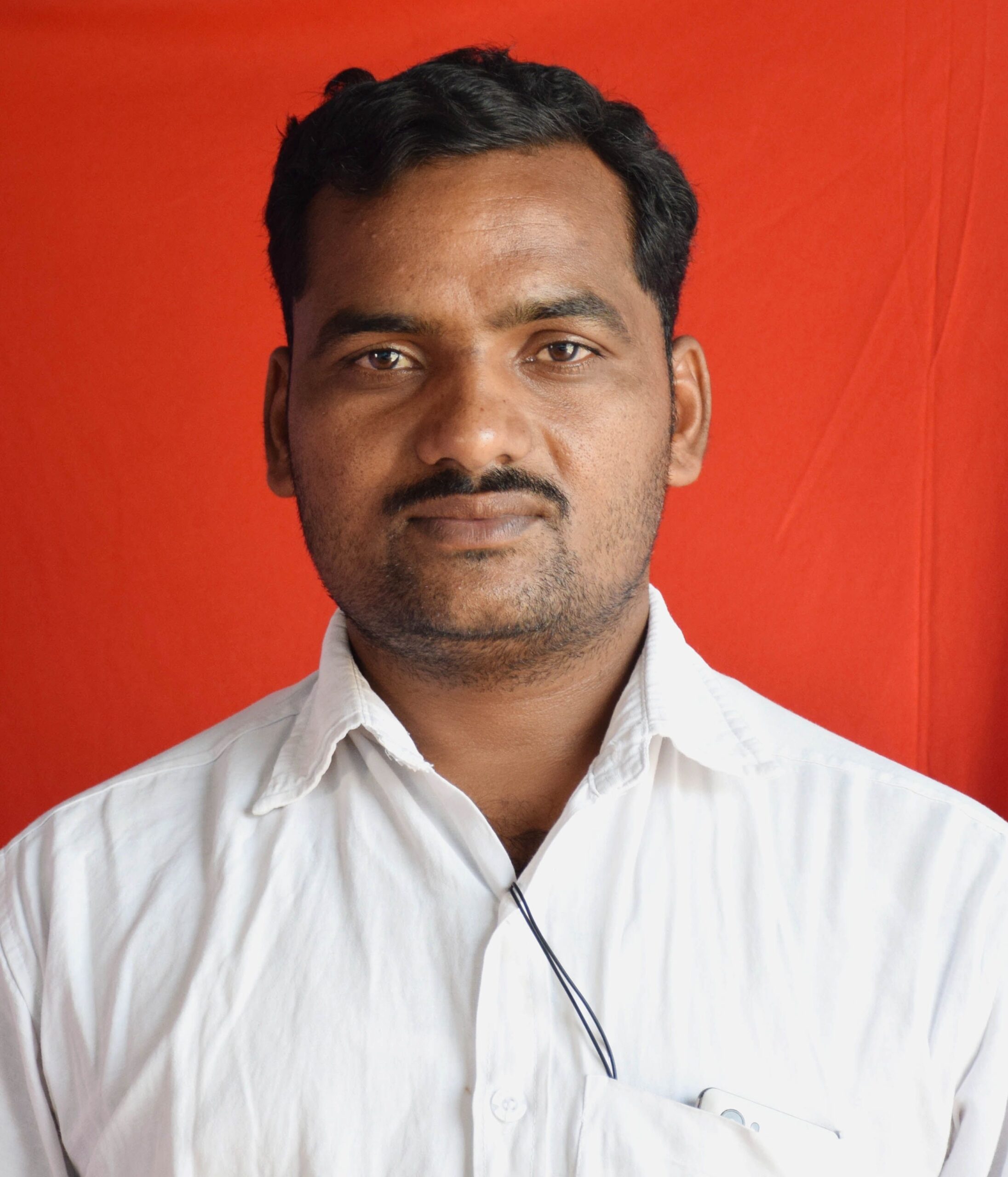 Portrait of a man in a white shirt with a red background. Fashion photography with a focus on expression.